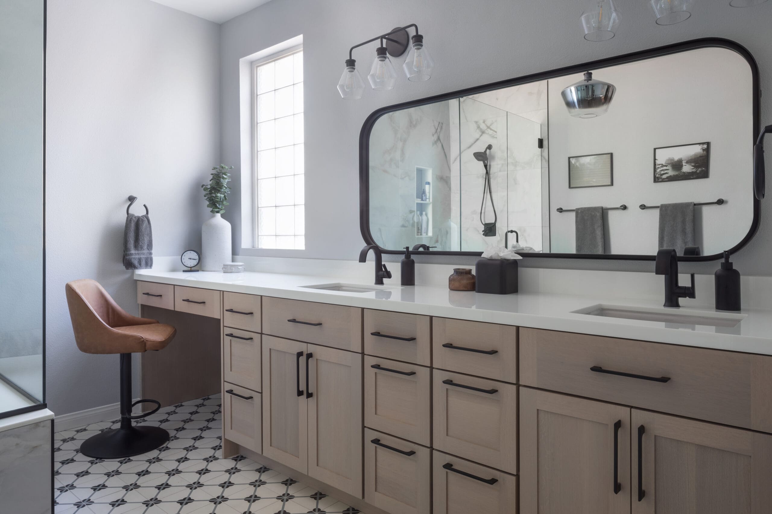 Custom bathroom remodel featuring dual vanities, quartz countertops, custom cabinetry, designer lighting, and a walk-in shower in a Las Vegas home.